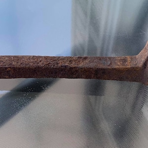 May include: A rusty metal nail with a flat head and a pointed tip.