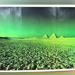 May include: A rectangular landscape print featuring the three pyramids of Giza set against a vibrant, solid green sky. The foreground displays a textured, dark, and uneven desert terrain that transitions into a lighter, lime-green horizon line.