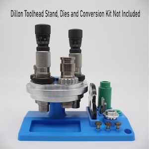 May include: A blue reloading press stand with a silver metal base and two black toolheads. The stand has a small tray and a green plastic tool holder. Dillon Toolhead Stand, Dies and Conversion Kit Not Included.
