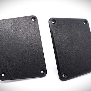 May include: Two black plastic square plates with rounded corners and four screw holes each.
