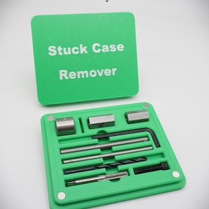 Puede incluir: Una caja de plástico verde con las palabras "Stuck Case Remover" en blanco. La caja está abierta, revelando varias herramientas metálicas, incluyendo una llave hexagonal, brocas y un macho de roscar. El texto "Stuck Case Removing Tools Not Included" está arriba.