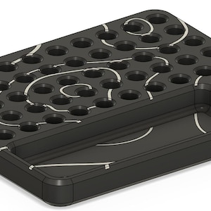 May include: A black rectangular tray with multiple circular holes and a recessed area. White swirl designs decorate the surface. The tray also features a small, angled compartment and a larger rectangular section.