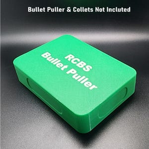 May include: A green rectangular box with the text "RCBS Bullet Puller" printed in white on the top.