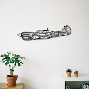 Peut inclure: Une décoration murale en métal noir représentant un avion P-40 Warhawk. L'œuvre d'art est une vue de profil de l'avion, avec des détails tels que le cockpit, les ailes et la queue. L'avion a un design de bouche de requin sur le nez et un emblème d'étoile. Il est monté sur un mur blanc.