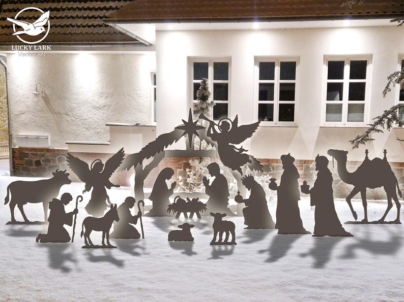 May include: A metal silhouette nativity scene with figures of Mary, Joseph, baby Jesus, angels, wise men, and animals. The figures are set against a snowy backdrop with a building and windows in the background. The scene is a festive holiday decoration.