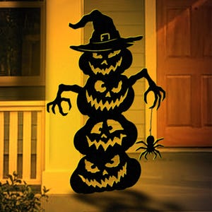 May include: Black Halloween decoration featuring three stacked jack-o'-lanterns with carved faces and a witch's hat. A spider hangs from the bottom pumpkin. The image includes text: "LUCKY LARK Vector Art" and "PDF File: US Letter / A4 Prints".