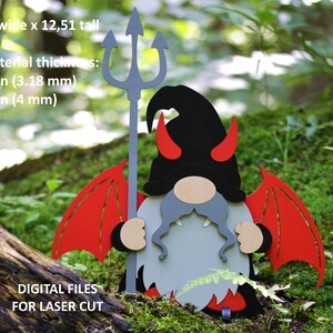 May include: A red and black devil gnome with wings, horns, and a trident. The gnome is holding the trident in its right hand. The gnome is standing on a bed of moss. The image includes the text "11,18 wide x 12,51 tall" and "for material thickness: 0.125 in (3.18 mm) 0.157 in (4 mm)".