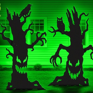 May include: Two black, flat, tree-shaped silhouettes with jagged, glowing green eyes and mouths. The left tree features a perched raven, while the right tree features a perched owl. Both trees have twisted, claw-like branches and textured bark.