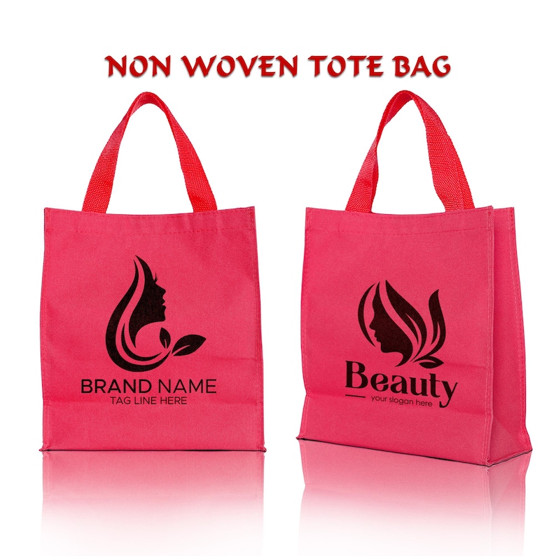May include: Two bright pink non-woven tote bags with red handles. The left bag features a black silhouette of a woman's profile and the text BRAND NAME TAG LINE HERE. The right bag displays a black silhouette logo and the text Beauty your slogan here.