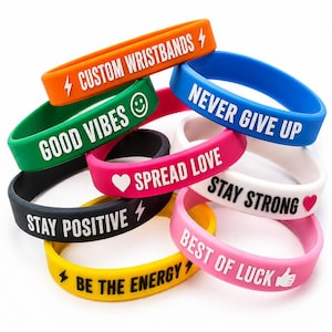 May include: A collection of colourful silicone wristbands featuring various phrases and symbols. The bands are orange, green, blue, white, black, yellow, and pink, with embossed white or black text including CUSTOM WRISTBANDS, GOOD VIBES, NEVER GIVE UP, SPREAD LOVE, STAY STRONG, STAY POSITIVE, BE THE ENERGY, and BEST OF LUCK.