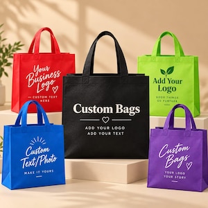 May include: Five non-woven tote bags in red, black, lime green, blue, and purple. Each bag features two handles and custom printed text and logos, including phrases like Your Business Logo, Custom Bags, Add Your Logo, and Custom Text/Photo.