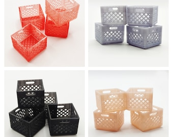 Op de afbeelding: Vier sets miniatuur melkkisten in vier verschillende kleuren: rood, grijs, zwart en perzik. Elke set bevat drie kisten die op elkaar gestapeld zijn.
