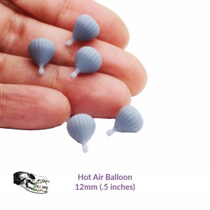 May include: Six miniature light blue hot air balloons, each approximately 12mm in size. The balloons have a ribbed texture and a small white attachment. The image includes the text "Hot Air Balloon" and size details.