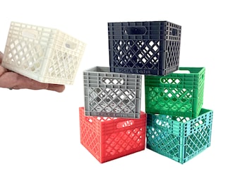 May include: A collection of six miniature plastic storage crates in white, black, gray, red, green, and teal. Each small square crate features a diamond-patterned lattice design, integrated side handles, and the text Scale Grail embossed on the base.