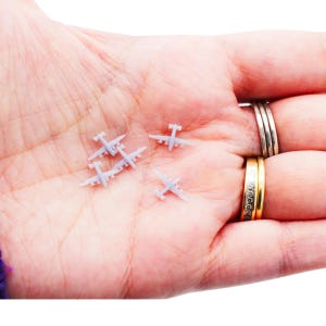 May include: A set of three ceramic mugs with a speckled, matte finish. The mugs are in shades of cream, light gray, and dark gray. Each mug has a simple, minimalist design, perfect for coffee or tea.