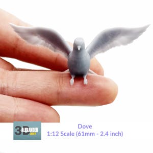 May include: A gray dove figurine with outstretched wings, measuring 2.4 inches in length. The figurine is held in a person's hand for scale.