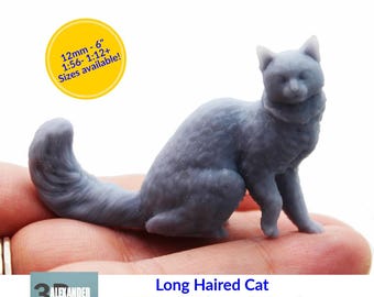 May include: A grey, long-haired cat figurine, approximately 2.5cm in length, in a seated position. The image includes text indicating various size options, including up to 15cm. The product is labeled as 1:12 scale.