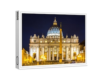 Può includere: Una vista notturna della Basilica di San Pietro a Roma, Italia. La basilica è illuminata da luci gialle calde, e la cupola è illuminata in un colore blu brillante. L'obelisco di fronte alla basilica è anche illuminato.