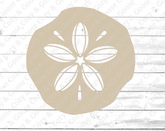 May include: A beige sand dollar with a white five-pointed star in the center. The sand dollar is on a white wood background.