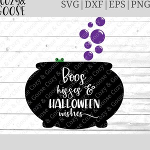 May include: Black cauldron with a green frog on top and purple bubbles rising from it. The text "Boos, hisses & Halloween wishes" is written on the cauldron.