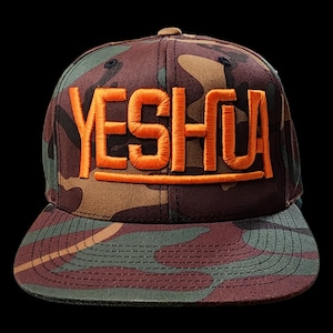 May include: A camouflage baseball cap with the word "YESHUA" embroidered in orange on the front.