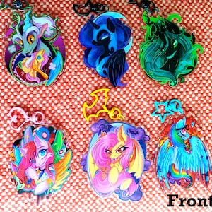 Op de afbeelding: Een verzameling kleurrijke acryl sleutelhangers met cartoonfiguren met verschillende ontwerpen. De sleutelhangers hebben verschillende vormen en kleuren, waaronder blauw, groen, roze en geel. Het woord "Front" staat rechtsonder.