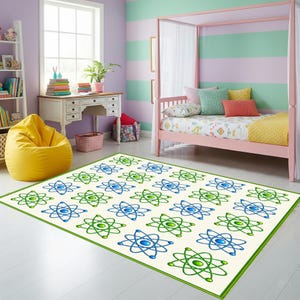 May include: A rectangular rug featuring a cream background and a repeating pattern of blue and green atom designs. The rug has a green border and is placed on a white floor in a child's bedroom.