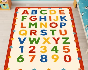 Puede incluir: Una alfombra rectangular con un centro de color crema que presenta el alfabeto de la A a la Z y los números del 1 al 0 impresos en varios colores, incluyendo rojo, azul, verde, amarillo y naranja, rodeada por un borde rojo con flores.