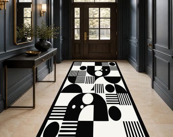 May include: A rectangular runner rug featuring a bold black and white geometric pattern. The design consists of various shapes including circles, semi-circles, and parallel line segments arranged in a repeating, high-contrast abstract composition.