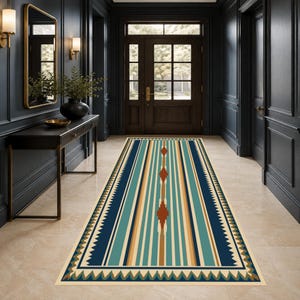 May include: A long rectangular runner rug featuring a geometric pattern with vertical stripes in shades of dark blue, teal, tan, and cream. The center design includes a series of rust-colored diamond shapes arranged in a line along the middle.
