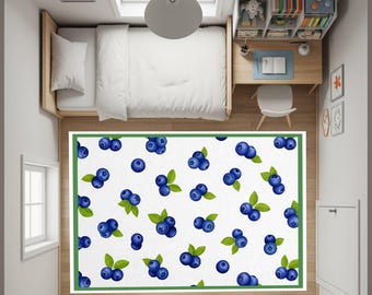 May include: Overhead view of a bedroom with a white bed, desk, and a rug. The rug features a white background with a pattern of blueberries and green leaves, framed by a green border. The room has a window and a skylight.