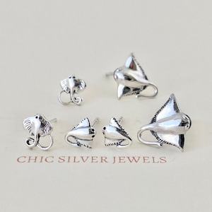 May include: A collection of silver-toned earrings in various designs, including stingrays and elephants. The earrings are displayed on a light-colored surface. The text "CHIC SILVER JEWELS" is visible at the bottom of the image.