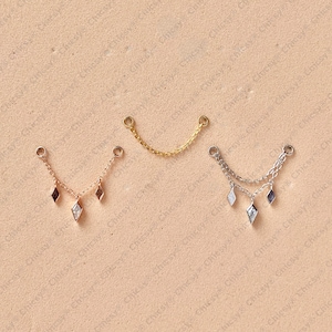 May include: Three delicate chain jewellery pieces. One is gold, the other is silver, and the third is rose gold. Each has a chain with a small charm. The rose gold and silver chains have diamond-shaped charms.