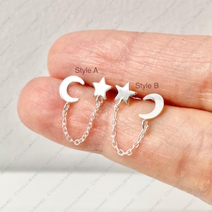 May include: Two pairs of silver earrings. Style A features a crescent moon and a star connected by a chain. Style B has a star and a crescent moon connected by a chain. The text "Style A" and "Style B" are visible.