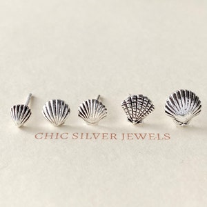 Pode incluir: Quatro pares de brincos de prata em forma de concha. Os brincos estão dispostos em fila, do menor para o maior.