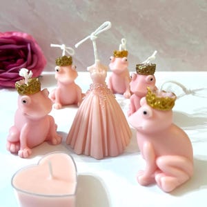 May include: Set of pink frog candles with gold crowns, a pink dress candle, and a pink heart candle. The candles are all hand-painted and have a delicate, feminine design.
