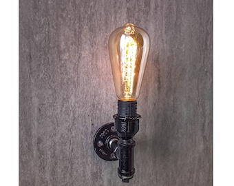 Könnte beinhalten: Eine schwarze Wandleuchte aus Metall mit einer Edison-Glühbirne im Vintage-Stil. Die Leuchte besteht aus industriellen Rohrverbindungen und hat einen rustikalen Look.