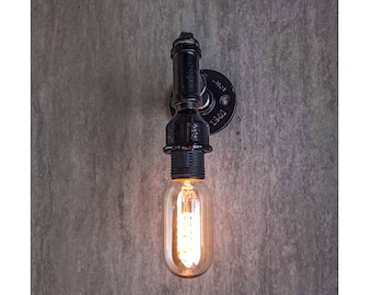 Könnte beinhalten: Schwarze industrielle Wandleuchte aus Rohr mit einer klaren Edison-Glühbirne aus Glas. Die Leuchte ist an einer grauen Wand montiert.