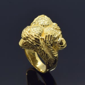 Peut inclure: Une bague en or avec un design détaillé de deux singes se faisant face. La bague est en or massif et a une finition lisse et polie.