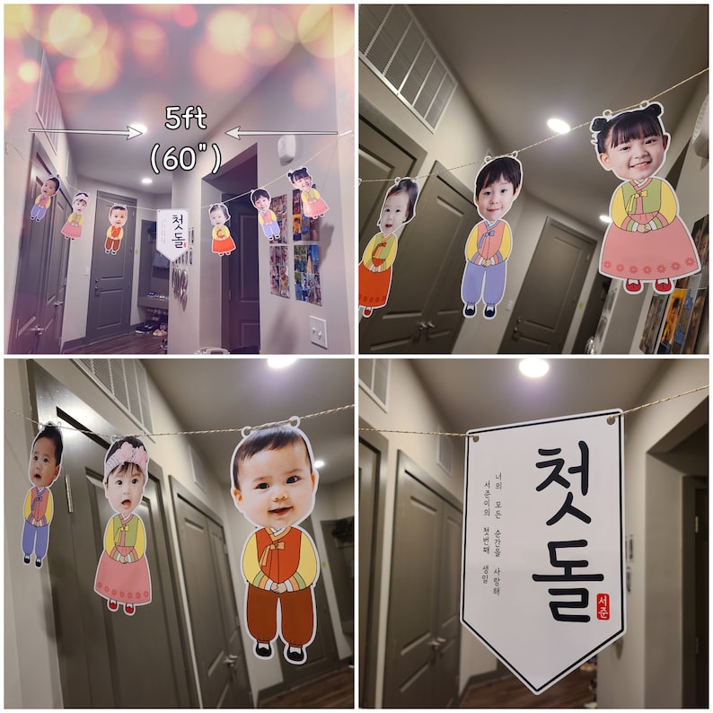 May include: A string of colorful paper cutouts with photos of children in traditional Korean clothing hangs from a ceiling. The cutouts are spaced 5 feet apart. A sign with the text "첫돌" in Korean is also hanging from the ceiling.