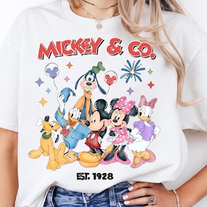 A woman wearing a white t-shirt with a graphic of Disney characters Mickey Mouse and Donald Duck.