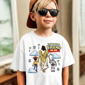 A young boy wearing a white t-shirt with a graphic design and sunglasses stands in a room.