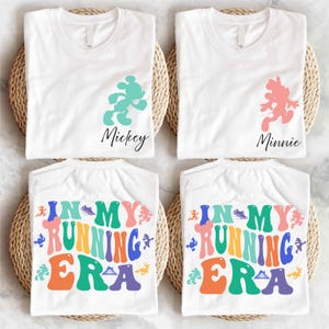 May include: Four white t-shirts with colorful retro text that reads "In My Running Era" and cartoon character silhouettes. The silhouettes are Mickey Mouse, Minnie Mouse, and two other characters.