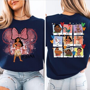 Puede incluir: Una sudadera azul marino con un lazo rosa y una imagen de dibujos animados de Moana de la pel&iacute;cula de Disney Moana. La parte posterior de la sudadera presenta una cuadr&iacute;cula de im&aacute;genes de dibujos animados de personajes de la pel&iacute;cula.