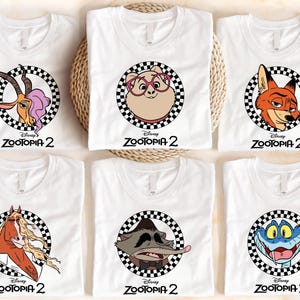 A collection of six white t-shirts with various cartoon animal characters printed on them, including a gazelle, a pig, a fox, a snake, a dragon, and a turtle.
