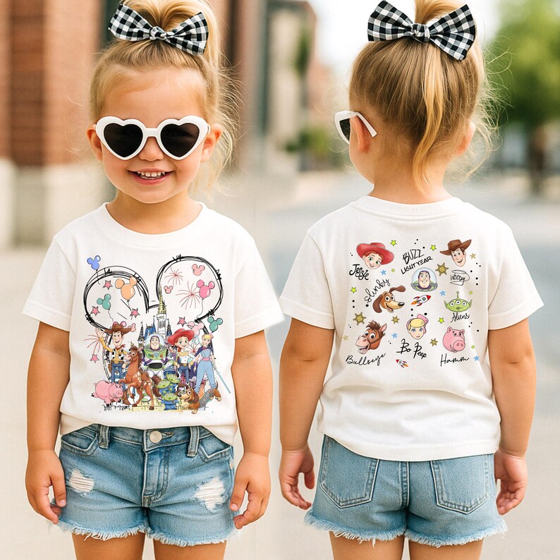 A young girl wearing a white t-shirt with a cartoon character design and heart-shaped sunglasses, standing on a street.