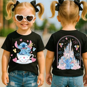A young girl wearing a black t-shirt with a cartoon character and a castle on it, smiling and posing for the camera.