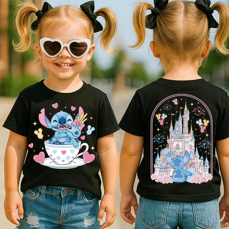 A young girl wearing a black t-shirt with a cartoon character and a castle on it, smiling and posing for the camera.
