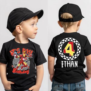 A young boy wearing a black t-shirt with a graphic design and the number 4 on the back.