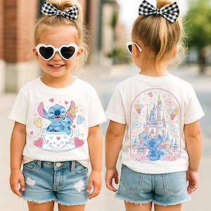 A young girl wearing a white t-shirt with a cartoon character and a castle on the back, smiling and wearing sunglasses.